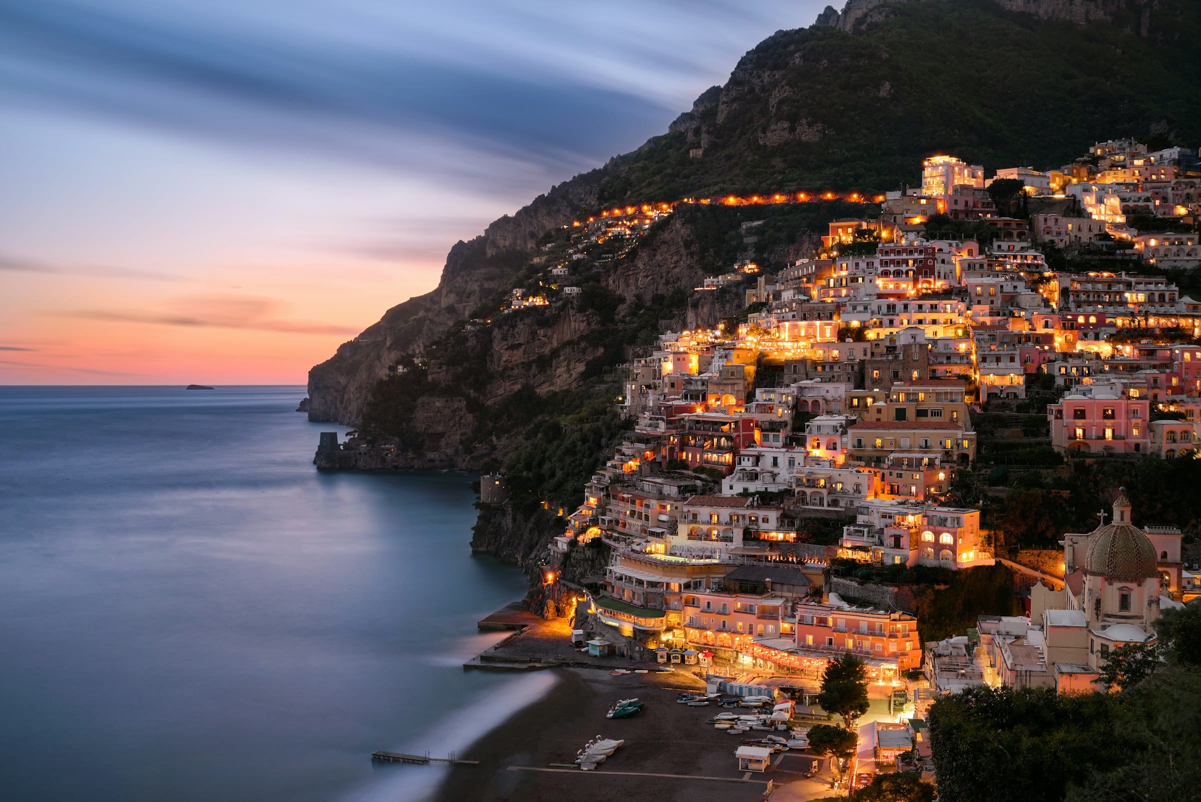 Fshati Positano i ndriçuar në muzg mbi Mesdhe
